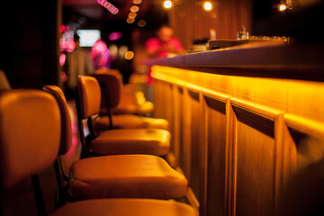 Brown leather chairs near the wooden bar in the bar, restaurant. Blurred image. The concept of rest