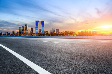 Cityscape of Suzhou City, Jiangsu Province, China. Asphalt road and modern city skyline scenery at sunset.