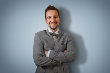 Young businessman in a suit on a light blue background