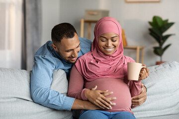 Happy Black Pregnant Muslim Couple Spending Time Together At Home