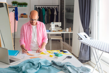clothing designer in his pattern workshop with fabrics, machines and sewing material designing clothes.
 - Powered by Adobe