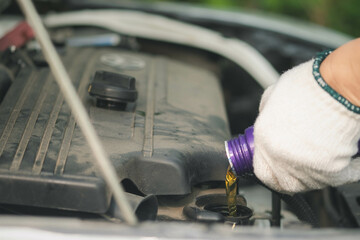 Car service, repair, maintenance concept. Close up of hands  electrician repairs car, tester and engine oil and nippers.call a technician broken car emergency on the way