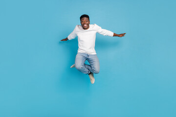 Full body photo of excited crazy man arms flight freedom good mood isolated on blue color background