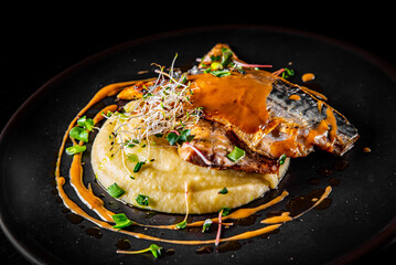 Fillet of mackerel with mashed potatoes and celery on dark background