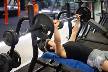Fototapeta na wymiar Bodybuilder lifting a weight on the flat bench