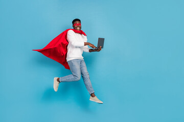 Full body portrait of handsome guy red cloak use wireless netbook digital connection isolated on blue color background © deagreez