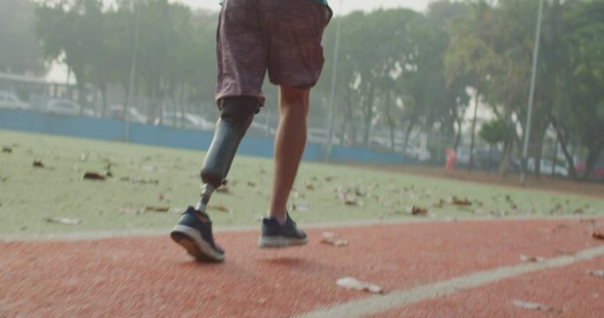 Disabled Athlete running with prosthetic leg at running track. Motivational amputee athlete runner