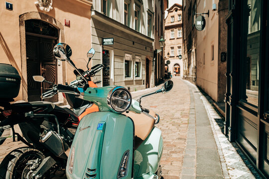 Prague, Czech Republic - July 2022. Retro Italian Vespa scooter in blue turquoise color on old european street. Motor bike, moped, transport mode, speed concept.