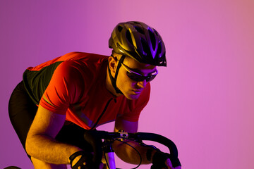 Caucasian male cyclist with bicycle over pink lighting