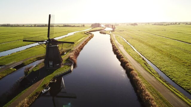 Aerial drone footage of a Dutch windmill in the countryside by sunrise.