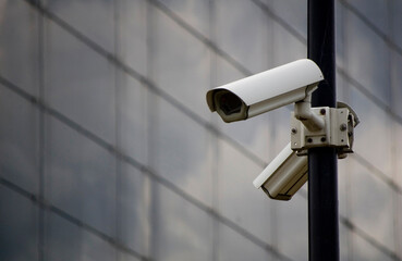 City monitoring system camera against building wall.