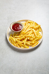 Golden potato chips french fries and ketchup on platter fast food