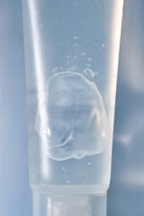 Transparent bottle of cosmetic gel on a blue background.