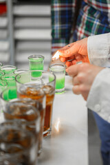 The bartender at the banquet makes cocktails.  At the banquet, the bartender pours alcohol. a lot of glasses.