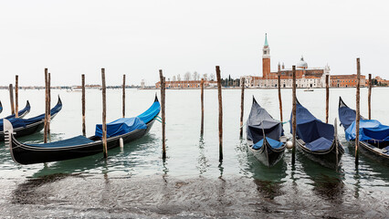 Fototapeta na wymiar Gondolas are moored in Saint Mark's Square. Church of San Giorgio di Maggiore in the background .Venice, Italy, Europe