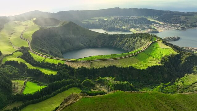Flying over Lagoa das Sete Cidades lake in sunny day. Sao Miguel Island, Azores, Portugal. Lakes in the craters of extinct volcanoes surrounded by green vegetation