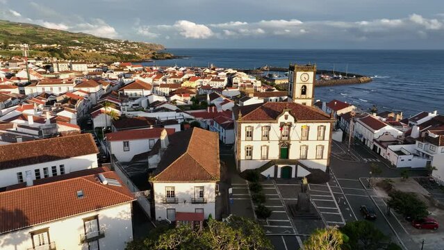 Aerial sunset view of Vila Franca do Campo, Azores. Flying around old white houses, marina and embankment near the ocean. Azores, Portugal