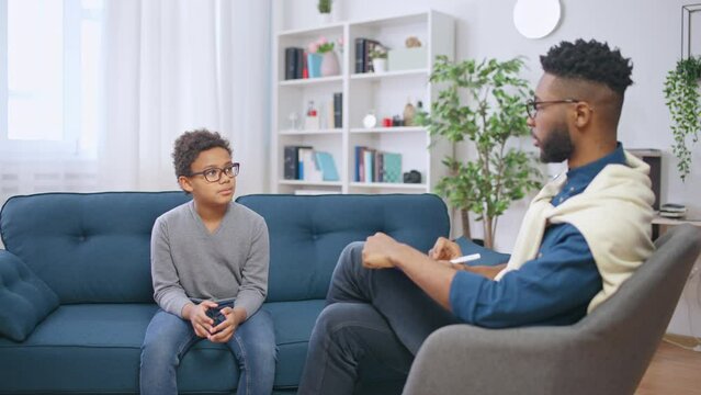 African American psychologist communicating with teenager, child counselling