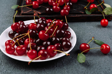 Fresh  ripe cherries on plate on betonics background