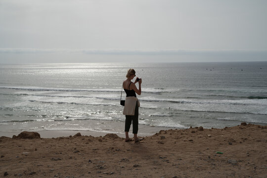 Woman taking pictures on the moroccan coastline