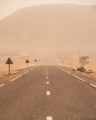 road going through the plateau during a sandstorm in Sahara Desert, Morocco Africa