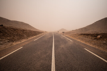 road going through the plateau during a sandstorm in Sahara Desert, Morocco Africa