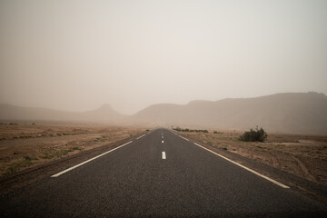 Fototapeta na wymiar road going through the plateau during a sandstorm in Sahara Desert, Morocco Africa