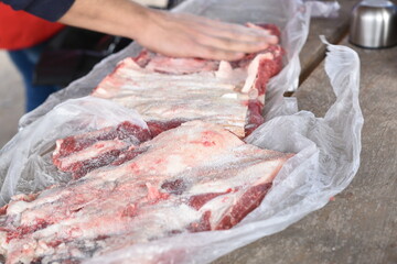argentinean man salting meat for the barbecue