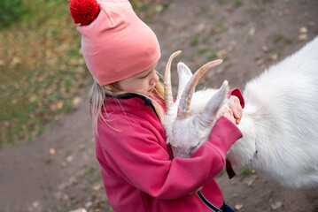 Little girl hugging goat,unusual pets,countryside life