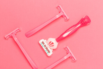 Female Hygiene Ideas. Closeup Image of Various Female Pink Disposable Razors Shavers Placed Bulk Over Trendy Pink Coral Background.