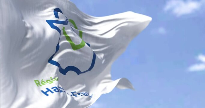 The flag of Hauts de France region waving in the wind on a clear day