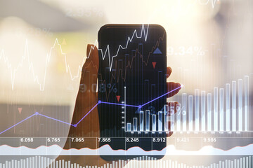 Abstract creative financial graph and hand with phone on background, forex and investment concept....