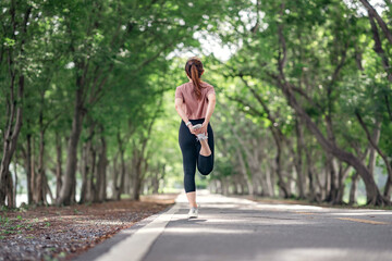 Fototapeta na wymiar Runner woman stretching legs before running in the park, healthy lifestyle and sport concepts, Warm up.