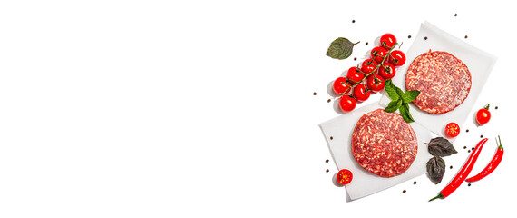 Raw steak cutlets from minced beef meat isolated on white background. Fresh vegetables, basil