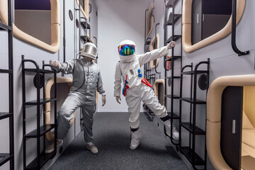 Portrait of astronauts in spacesuit in capsule hotel sleeping module