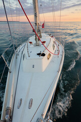 Yacht sailing in an open Baltic sea at sunset. Top down view of the deck and mast. Clear sky,...
