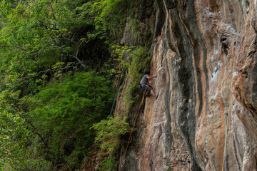 The sport of rock climbing is popular with adventurous tourists coming to Rai Loei Beach, Krabi province, southern Thailand 