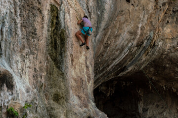 Male tourists wearing safety gear with ropes and climbing equipment are climbing the cliffs must be strong and excited. adventure sports concept