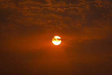 Obraz premium Extreme Closeup shot of sun behind the clouds during the sunset. Sun during the sunset background. Natural sunset background