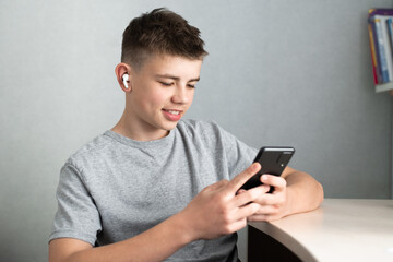 teenage boy using smartphone for study or communication, smiling and looking at screen