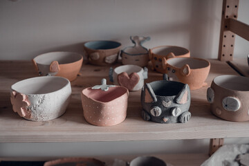 hand made ceramics dishes on shelves, pottery workshop