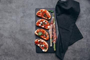 Snacks in the restaurant bruschetta with tomatoes and asparagus with prosciutto and olives two glasses of white wine or prosecco