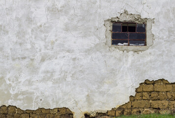 Beautiful detail of an old facade of a Colombian farm : adobe brick wall painted in white, old...