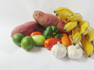 banana, potato, garlic, bell pepper, carrot, tomato and lemon a white background with copy space