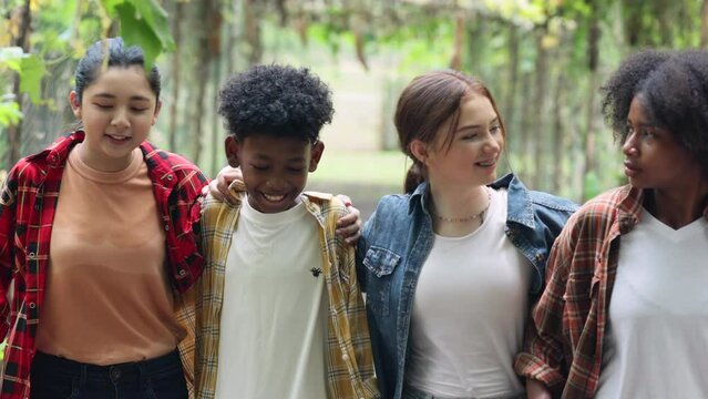 Happy Multi-Cultural Children teenage. Group portrait diverse teenage boy and girls. Kids walking talking leaning outdoor summer camp