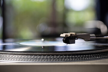 Focus on The Headshell Cartridge and Stylus of Classic Vintage Vinyl Record Player Playing on Vinyl Record Music