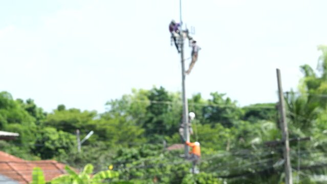 Blurred  Electricians are working on the post, out door  Chiangmai Thailand.