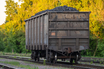 Fototapeta na wymiar RU, Moscow 07.06.2022: Separately standing on the railway tracks one wagon with coal. Freight railway wagon separately from the train.