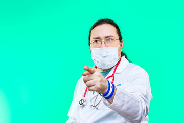 A doctor in a white coat and mask points forward with his finger. Bracelet in the colors of the flag of Israel.