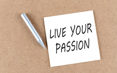 LIVE YOUR PASSION text on sticky note on a cork board with pencil ,